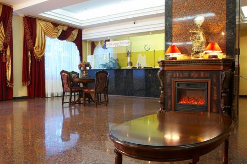 a living room with a fireplace and a table at Dniprovski Zori in Kremenchuk