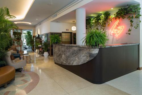 a lobby with a reception counter with plants at Generator Miami in Miami Beach