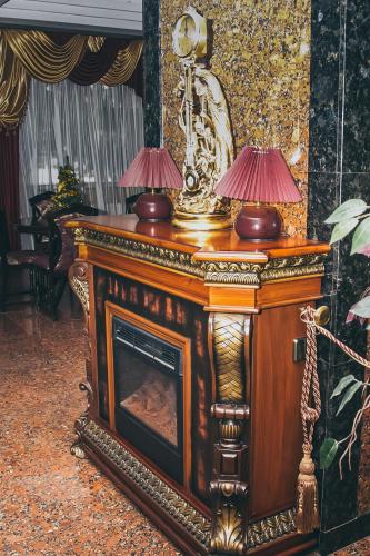 a wooden fireplace with two lamps on top of it at Dniprovski Zori in Kremenchuk