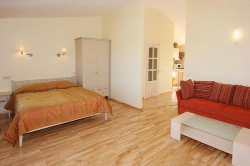 a bedroom with a bed and a couch at Vila Verbena in Palanga