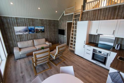 a small living room with a couch and a kitchen at Norsk Havbrukssenter - Rorbuer in Brønnøysund
