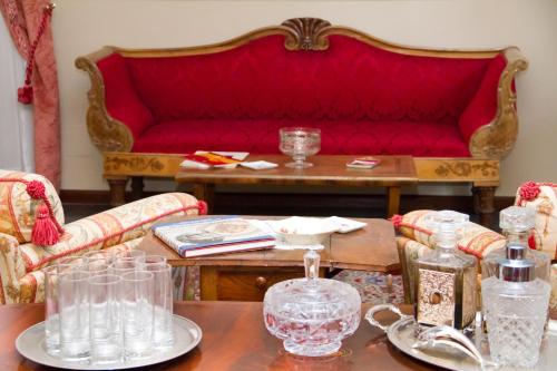 een woonkamer met een rode bank en een tafel bij Il Giardino Segreto di Ascoli Piceno in Ascoli Piceno
