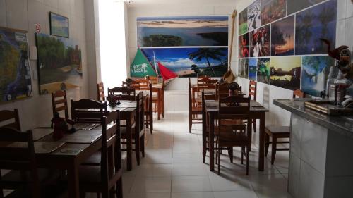 uma sala de jantar com mesas e cadeiras num restaurante em Pousada Maramazon em São Luís