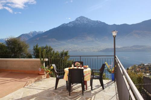 a table and chairs on a balcony with a view of the mountains at Residence Le Azalee & SPA in Vercana