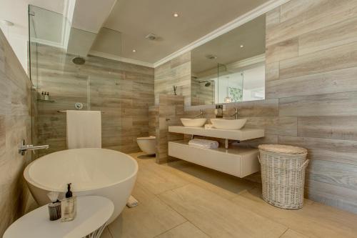 a bathroom with two sinks and a tub at Amanzi Island Boutique Hotel in Knysna