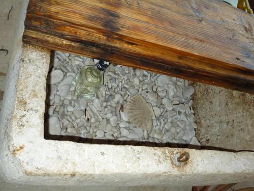 a rock garden under a bench with a plant at Picić Guesthouse in Luka