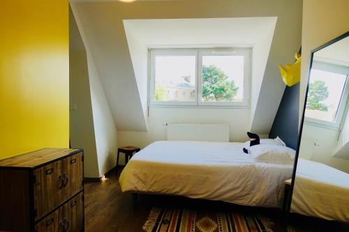 une chambre avec un grand lit et une fenêtre dans l'établissement Duplex Hermine Cosy, jardin sud & parking, à Saint-Malo
