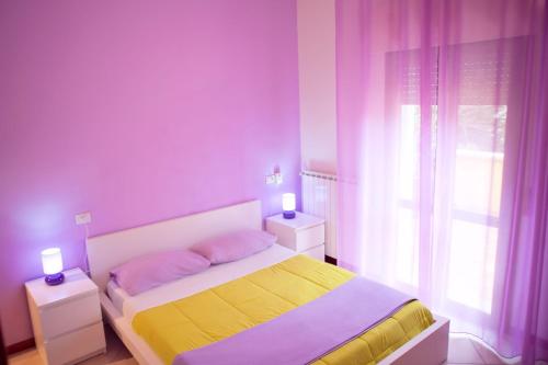 a bedroom with a bed with two night stands and a window at As Easy in Assisi