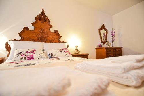 パレーデス・デ・コウラにあるCasa Freitasのベッドルーム1室(白いシーツと木製ヘッドボード付きのベッド1台付)