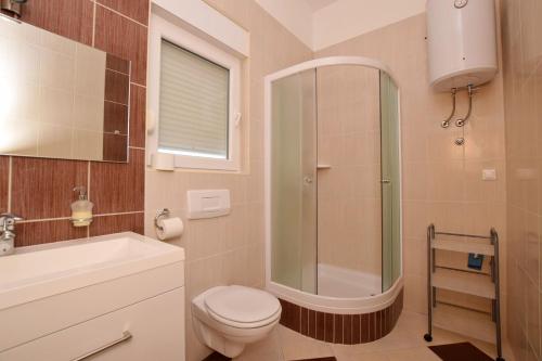 ein Bad mit einer Dusche, einem WC und einem Waschbecken in der Unterkunft Apartment DIVA in Nin