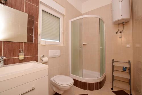 un bagno con doccia, WC e lavandino di Apartment DIVA a Nin