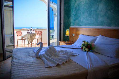 a bedroom with a bed with a swan on it at Abbaidda Hotel in Valledoria