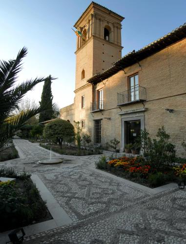 a building with a clock tower in a courtyard at Parador de Granada in Granada