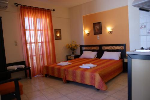 ein Schlafzimmer mit einem Bett mit einer orangefarbenen Tagesdecke in der Unterkunft Verykokkos on the beach in Agia Anna