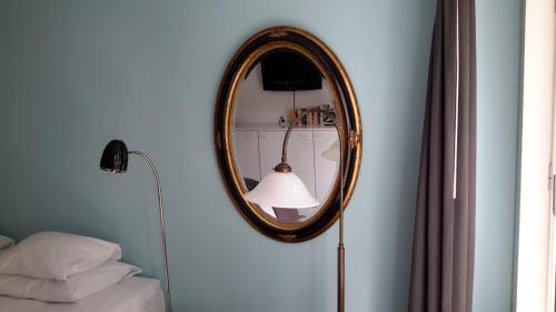 a mirror on a wall next to a bed at Bed & Breakfast WestViolet in Amsterdam