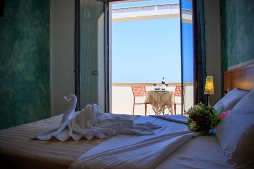 a bedroom with a bed with a swan on it at Abbaidda Hotel in Valledoria