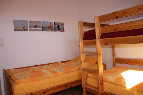 1 Schlafzimmer mit 2 Etagenbetten und einer Leiter in der Unterkunft Nickelshus Whg. Robin in Sankt Peter-Ording
