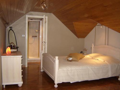 a bedroom with a white bed with a teddy bear on it at B&B Wisteria in Herne