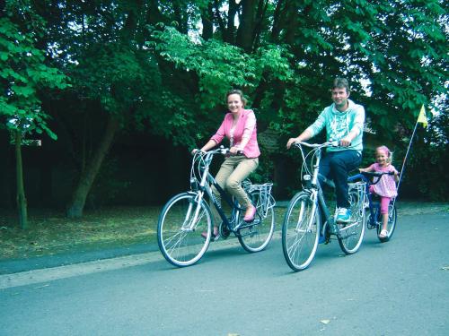 a man and a woman riding bikes with a child at B&B Wisteria in Herne