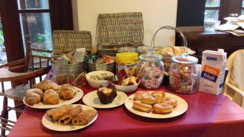 a table with plates of pastries and jars of food at Osteria alle Risorgive in Codroipo