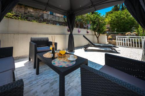 a patio with a table and chairs and an umbrella at Luxury apartment Antonija-old town in Cavtat