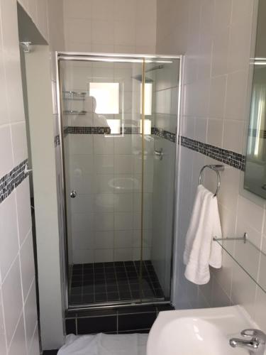 uma casa de banho com um chuveiro, um WC e um lavatório. em Pearl Oyster guesthouse em St Francis Bay