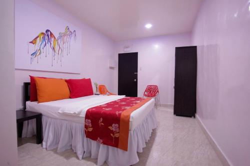 a bedroom with a bed with a red blanket on it at HalfWay House Hostel Mactan Cebu Airport in Mactan