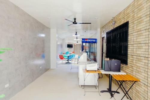 a room with tables and chairs and a brick wall at HalfWay House Hostel Mactan Cebu Airport in Mactan