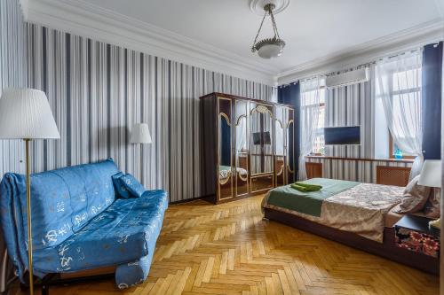 モスクワにあるАпартаменты на Плющихе 44/2のベッドルーム(青いソファ、ベッド付)