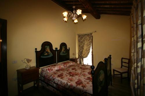 a bedroom with a bed and a chandelier at Il Mulino del Rigualdo in Torniella