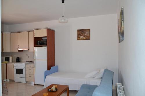 Apartamento pequeño con sofá blanco y cocina en Spacious 1 bedroom apartment 2 km to Pessada beach, en Dhorizáta