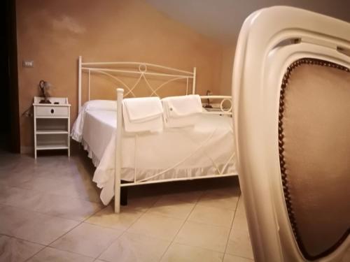 1 dormitorio con cama blanca y almohadas blancas en La Rosa Del Barone en Cancellara