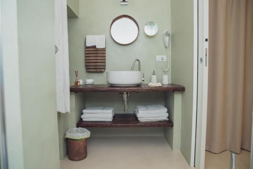 a bathroom with a sink and a mirror and towels at CASA MELIO' in Polignano a Mare