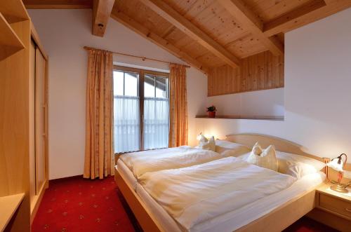 a bedroom with a large bed and a window at Appartments Antoniushof in Ellmau