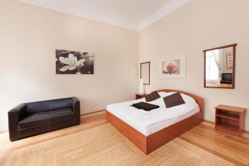 una camera con letto e poltrona in pelle di Karma Boutique Apartments a Budapest
