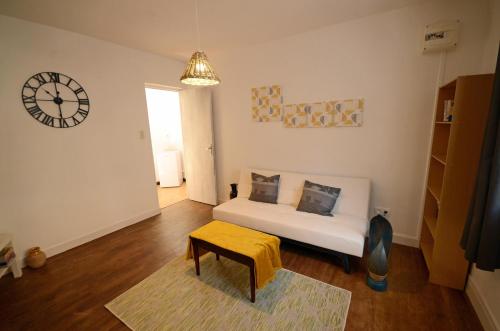 une chambre avec un lit et une horloge au mur dans l'établissement La petite soixante deux, à Le Lonzac