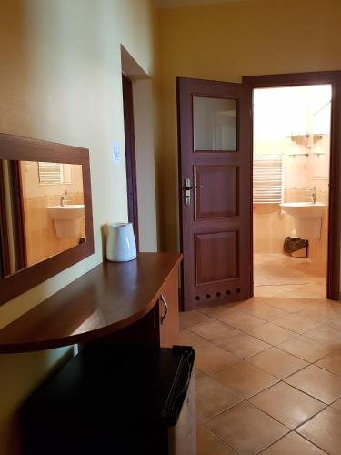 a bathroom with a sink and a mirror and a door at Posejdon in Ustronie Morskie