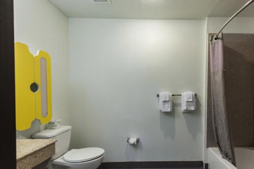 a small bathroom with a toilet and a shower at Studio 6-Port Arthur, TX - SE in Port Arthur