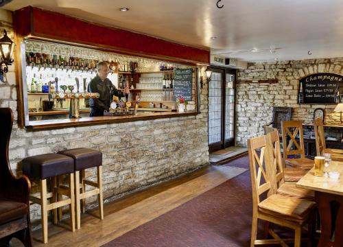 a bar with a man standing behind the bar at Best Western Compass Inn in Tormarton