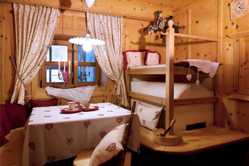 a room with a bunk bed and a table in a room at Hotel Italia in Corvara in Badia