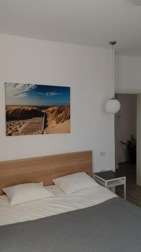 a bedroom with a large bed with a wooden headboard at Sea Sound Apartment Mamaia Nord in Mamaia Sat/Năvodari