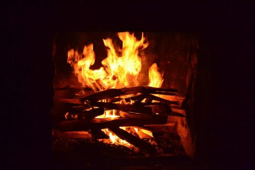a fire in a fireplace with flames in it at Villa Pajon Eco Lodge in Constanza