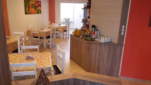 een keuken en eetkamer met een aanrecht en tafels bij Pousada Valentina in Penha