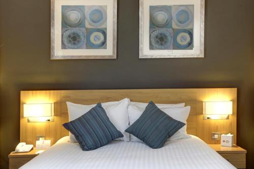 a bedroom with a bed with two lamps and two pillows at Best Western Plus Nottingham Westminster Hotel in Nottingham