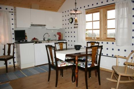 uma cozinha com mesa e cadeiras num quarto em Ulvsby Ranch em Karlstad