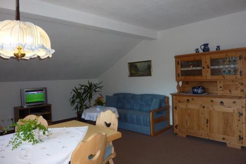 a living room with a blue couch and a table at Tratlhof in Achenkirch