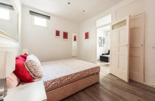 マドリードにあるApartamento en SOL, Madrid Centroのベッドルーム1室(赤い枕のベッド1台付)