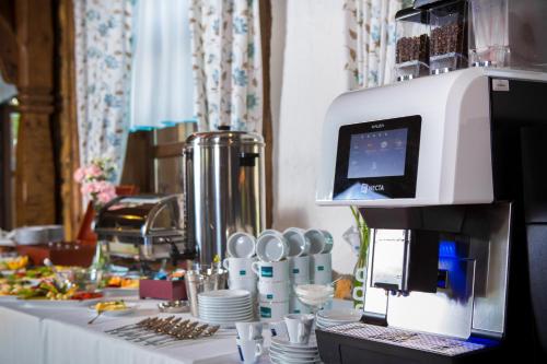 eine Kaffeemaschine auf einem Tisch mit Tellern in der Unterkunft Dwór Bogucin Hotel&Restauracja in Bogucin