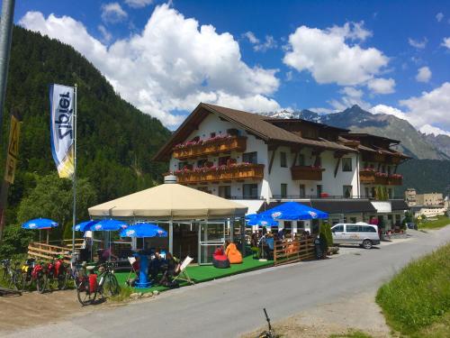 a large building with blue umbrellas in front of it at Gasthof Martha in Nauders