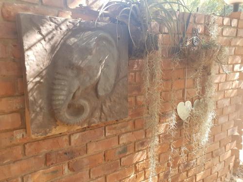 an elephant statue on a brick wall with plants at Suikerbosrant Sleep and go in Pretoria